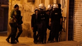 Bahraini riot police enter a house during a raid to arrest suspected protesters involved in clashes (file photo).