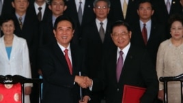 Chen Yunlin, left, shakes hands with Chiang Pin-kung, after signing investment protection pact, Taipei, Taiwan, August 9, 2012. 