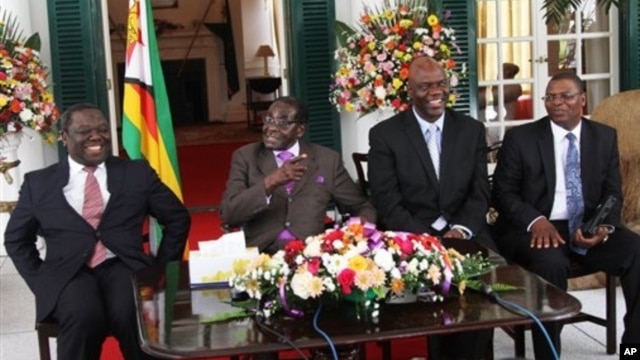 From left, Prime Minister Morgan Tsvangirai, President Robert Mugabe and other Zimbabwean officials address a press conference at the State House, Harare, Jan. 17, 2013.