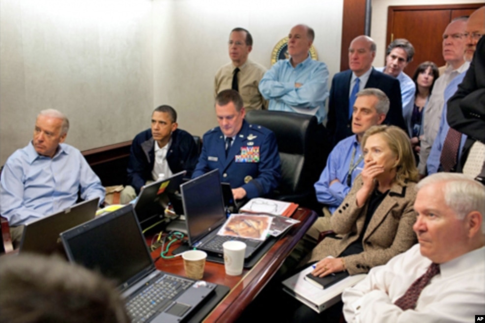 2011年5月1日，美国高官在白宫战情室监看美军突袭本拉登的行动。奥巴马总统，拜登副总统（最左），国防部长盖茨（最右），国务卿克林顿（前排右起第二人）。