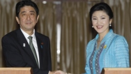 Japanese Prime Minister Shinzo Abe, left, poses with his Thai counterpart Yingluck Shinawatra for photographers at the end of a news conference at the Government House in Bangkok, Thailand, January 17, 2013.