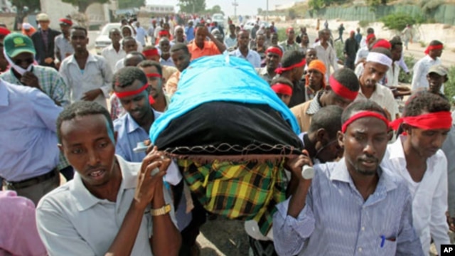 Somali journalists carry the slain body of their colleague, Abdisalan Sheikh Hasan, during his funeral in southern Mogadishu, Somalia, December 19, 2011.