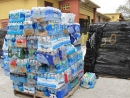 Palettes of bottled water destined for Haiti are neatly placed in Notre Dame d'Haiti church's parking lot, 3 Mar 2010