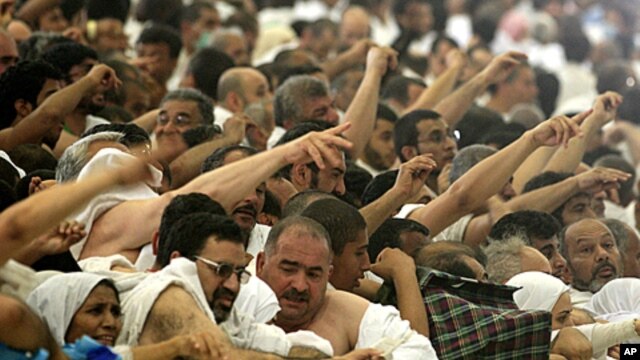 Muslim pilgrims cast stones at a pillar, symbolizing the stoning of Satan, in a ritual called "Jamarat," the last rite of the annual hajj, in Mina near the Saudi holy city of Mecca, Saudi Arabia, Nov. 6, 2011.