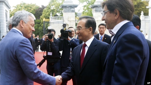 Chinese Premier Wen Jiabao, center, is greeted by Belgian PM Elio Di Rupo, right, and Belgian FM Didier Reynders prior to a meeting at the Egmont Palace in Brussels, September 20, 2012. 