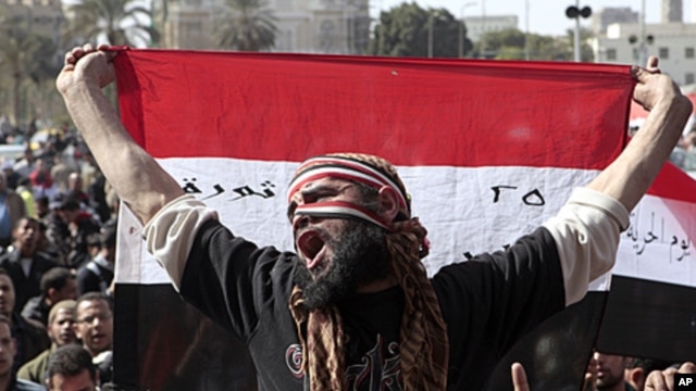 An Egyptian protester holds a national flag and chants anti-ruling military council slogans during a protest after Friday prayers at Tahrir Square, in Cairo, February 10, 2012.