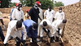 Health workers remove earth contaminated by lead from a family compound in the village of Dareta in Gusau, Nigeria, June 10, 2010.