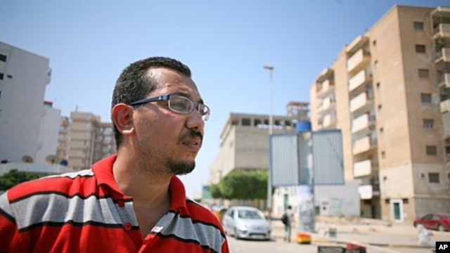 Wahabi Mohammed Yemeni stands at a checkpoint in his neighborhood in Tripoli, August 31, 2011