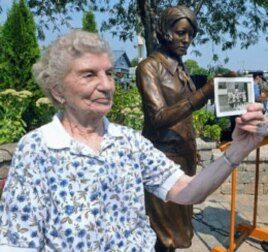 Next to the 'Radium Girls' statue, Rose Baima, who worked at Luminous Process, holds a photo of her and her co-workers during the 1940's, September 2, 2011.