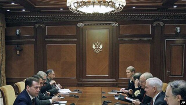 Russian President Dmitry Medvedev, left, speaks to US Defense Secretary Robert Gates, second right, during their meeting at which they discussed the planned missile defense system in Europe, at the Gorki residence outside Moscow, March 22, 2011