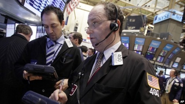 Gordon Charlop, right, works with fellow traders on the floor of the New York Stock Exchange. (March 2012 file photo)
