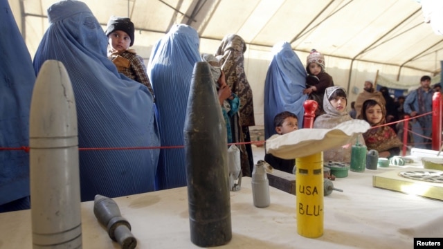 Afghan refugees family returning from Pakistan look at explosives and mines during an awareness program at the United Nations High Commissioner for Refugees registration center in Mommand Dara district in Jalalabad province, November 20, 2012.