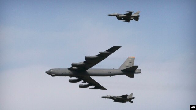Un bombardero B-52 vuela sobre la base Osan en Pyeongtaek, Corea del Sur, escoltado por dos aviones caza.