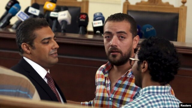 Phóng viên truyền hình Al Jazeera Mohamed Fahmy (trái) và Baher Mohamed (giữa) trước khi nghe phán quyết tại một tòa án ở Cairo, Ai Cập, ngày 29/8/2015.