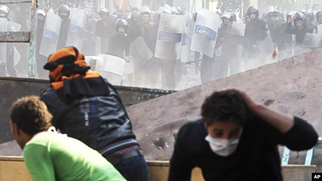 Protesters and police throw stones during clashes near Tahrir Square in Cairo, November 23, 2011.