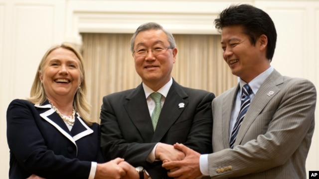 U.S. Secretary of State Hillary Rodham Clinton, left, South Korean Foreign Minister Kim Sung-hwan, center, and Japanese Foreign Minister Koichiro Gemba shake hands before their trilateral meeting during the ASEAN Regional forum in Phnom Penh, Cambodia, Ju
