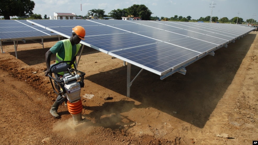 In this photo taken June 30, 2016, a Ugandan worker levels the ground at a solar plant in Soroti about 300 kilometers east of Uganda capital Kampala.