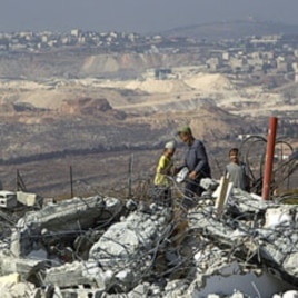 Jewish settler boys stand atop ruins of razed buildings in the unauthorized Jewish hilltop outpost of Migron, near the West Bank city of Ramallah, September 5, 2011.