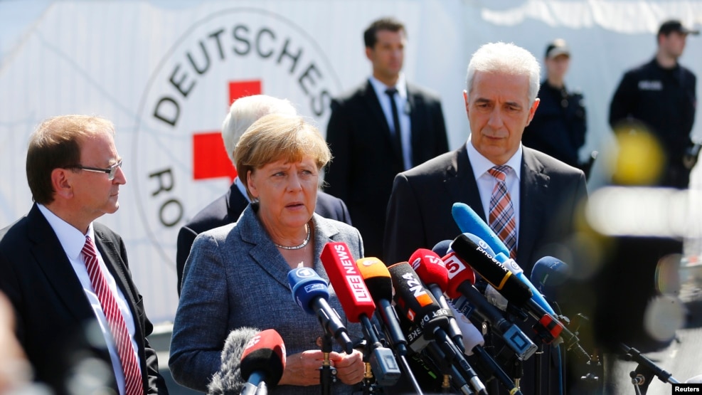 Heidenau Mayor Juergen Opitz, German Chancellor Angela Merkel and Saxony State Prime Minister Stanislaw Tillich (L to R) arrive for statements after their visit to an asylum seekers accommodation facility, Aug. 26, 2015.