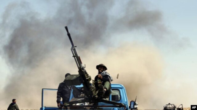 A Libyan rebel fighter sits on a truck as he fires an anti-aircraft gun on a government warplane (file photo)
