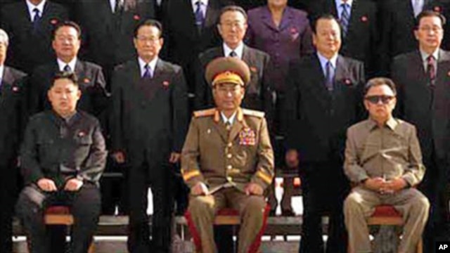 In this undated photo released on Thursday, Sept. 30, 2010, by Korean Central News Agency, North Korean Leader Kim Jong Il, right, poses for a group photo with newly elected members of the central leadership body of the Workers Party of Korea and the part