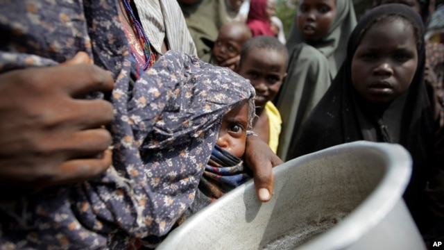 A woman carrying her baby queues for food in a camp established by the Somali Transitional Federal Government for the internally displaced people in Mogadishu.