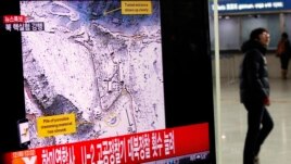 A passenger walks past a television report on North Korea's nuclear test at a railway station in Seoul February 12, 2013.