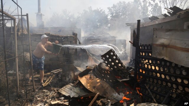 Cư dân dập tắt ngọn lửa tại ngôi nhà đang cháy ở Donetsk, ngày 7/9/2014.