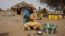 In this Tuesday, May 1, 2012 photo, Maryam Sy comforts her 2-year-old son Aliou Seyni Diallo, the youngest of nine, after a neighbor gave him dry couscous to stop him from crying with hunger, in the village of Goudoude Diobe, in the Matam region of northe