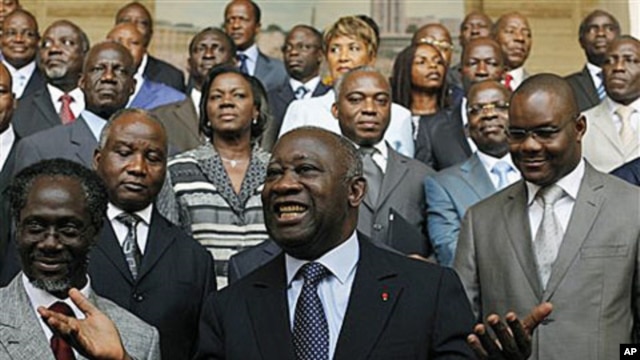 Incumbent President Laurent Gbagbo, center, gestures during a photo opportunity with his newly-named cabinet, with Prime Minister N'Gbo Gilbert Marie Ake, front left, at the presidency in Abidjan, Ivory Coast, Dec 7, 2010