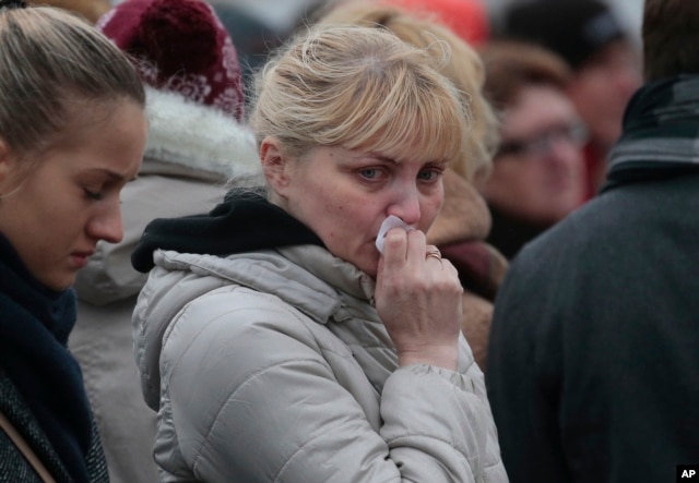 People react as they come to lay flowers in memory of the plane crash victims at Dvortsovaya (Palace) Square in St.Petersburg, Russia, on Wednesday, Nov. 4, 2015.