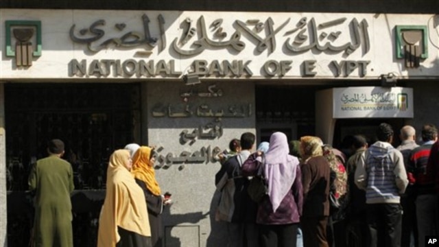 Egyptians wait at an automatic cash dispenser (ATM) in Cairo, Egypt, February 2, 2011