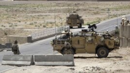 British troops keep watch at a checkpoint, where an Afghan policeman shot and killed three British soldiers, in Helmand province July 2, 2012.