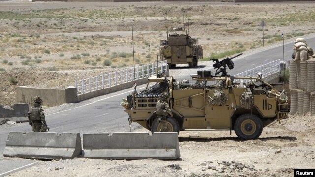 British troops keep watch at a checkpoint, where a man shot and killed three British soldiers, Helmand province, Afghanistan, July 2, 2012.