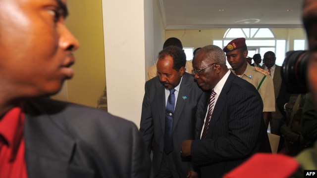Somalia's newly elected President Hassan Sheikh Mohamud (C) and Kenya's Foreign Affairs Minister Sam Ongeri (2nd R) leave the Jazeera hotel after a bomb blast outside the venue in Mogadishu, September 12, 2012.
