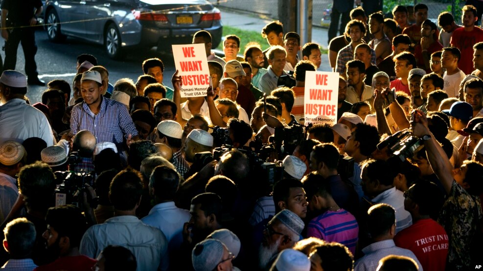 People gather for a demonstration Saturday, Aug. 13, 2016, near a crime scene after an imam and his friend were fatally shot while walking home from a mosque. Police said 55-year-old Imam Maulama Akonjee and his 64-year-old associate, Tharam Uddin, were shot in the back of the head as they left the Al-Furqan Jame Masjid mosque in the Ozone Park section of Queens.