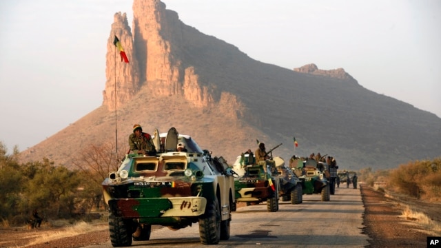 A convoy of Malian troops makes a stop to test their weapons near Hambori, northern Mali, on the road to Gao, February 4, 2013. 