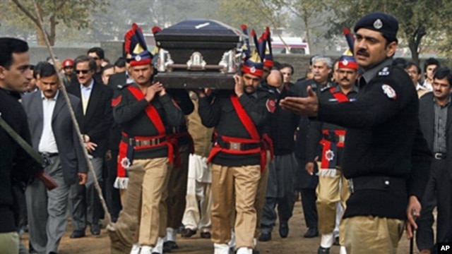 Pakistani police guards carry the coffin of late Punjab governor Salman Taseer during the funeral procession in Lahore on Jan 5, 2011.