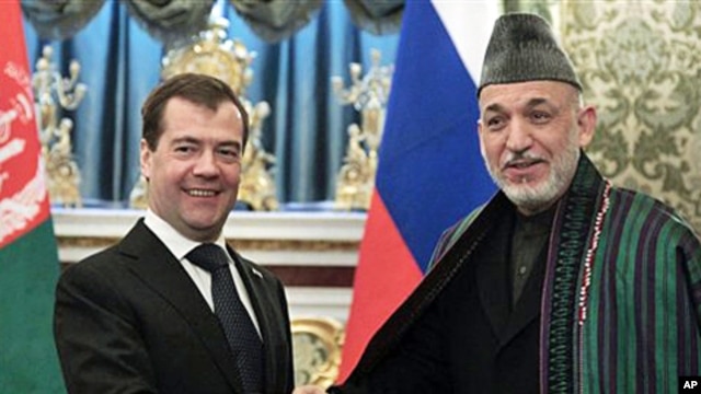 Russian President Dmitry Medvedev, left, shakes hands with Afghan President Hamid Karzai during their meeting in Moscow's Kremlin, Russia, 21 Jan 2011
