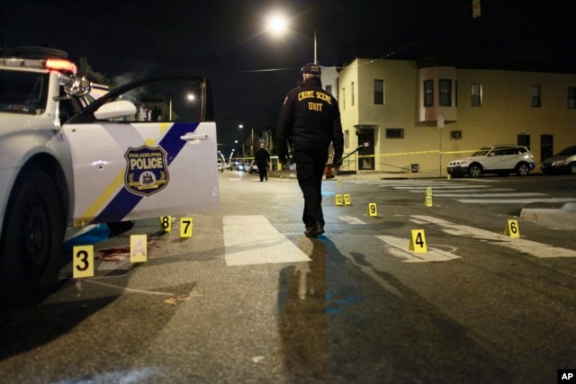 An investigator walks through the scene of a shooting, Jan. 8, 2016, in Philadelphia.