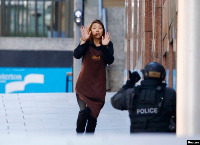 Một con tin chạy về phía cảnh sát đang bao vây bên ngoài quán café Lindt ở khu vực Martin Place, Sydney, Australia, 15/12/2014.