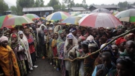 Internally displaced Congolese men and women wait for a World Food Program energy biscuits to be distributed in Kibati, north of Goma, eastern DRC, August 8, 2012.