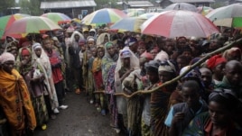 Internally displaced Congolese men and women wait for a World Food Program energy biscuits to be distributed in Kibati, north of Goma, eastern DRC, August 8, 2012.