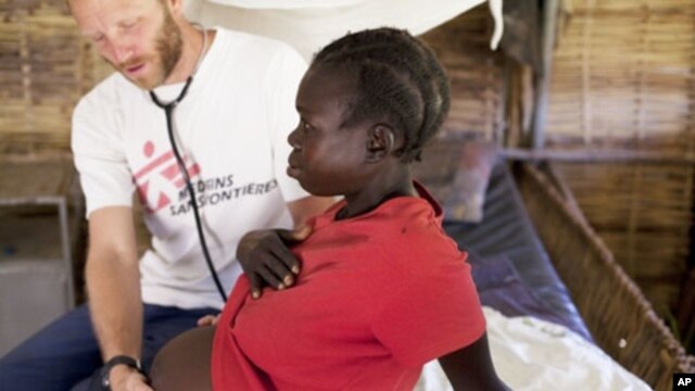 MSF HIV specialist Dr. Eamonn Vitt examines an HIV positive Ugandan woman who's 7 months pregnant. (Nov. 2009)