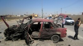 People inspect the site of a car bomb attack on cars lined up at a gas station in the oil rich city of Kirkuk, in northern Iraq, July 10, 2014.