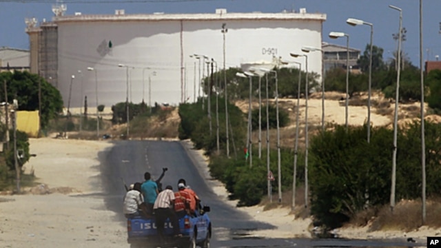 A truck carrying Libyan rebel fighters drives towards the Zawiya oil refinery in Zawiyah, August 17, 2011