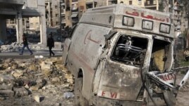 Residents walk past a damaged emergency vehicle in Aleppo, Syria, January 1, 2013.