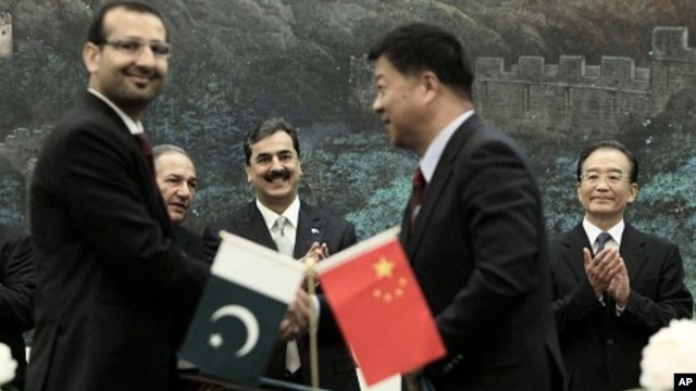 Pakistan's Prime Minister Yousuf Raza Gilani, center, and China's Premier Wen Jiabao, right, clap at a singing ceremony at the Great Hall of the People in Beijing, May 18, 2011