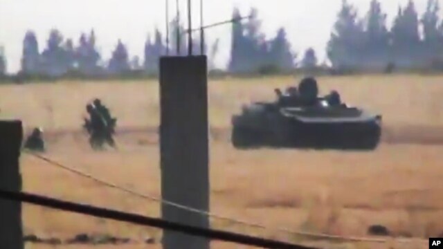This image made from amateur video released by the Shaam News Network and accessed June 18, 2012, purports to show a Syrian military tank in Daraa, Syria. 