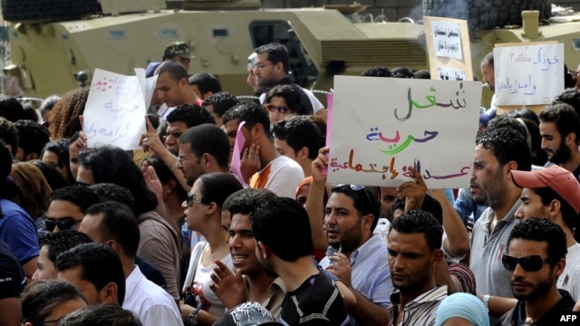 Unemployed Tunisian graduates hold signs as they shout slogans during a demonstration in Tunis to demand jobs and call for the resignation of the ruling government, September 29, 2012.